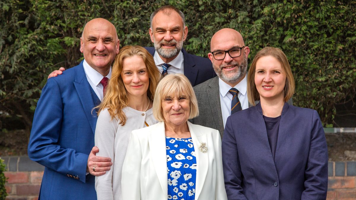 Carol posa con sus cinco hijos para la foto con una sonrisa de oreja a oreja.
