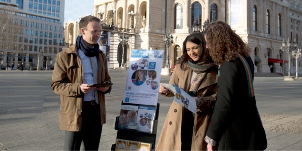 Jonathan y Mayli Gündel hablando de la Biblia a las personas en una plaza