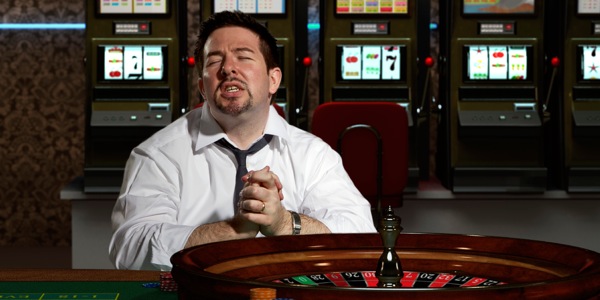 مردی جلوی میز قمار دعا می‌کند