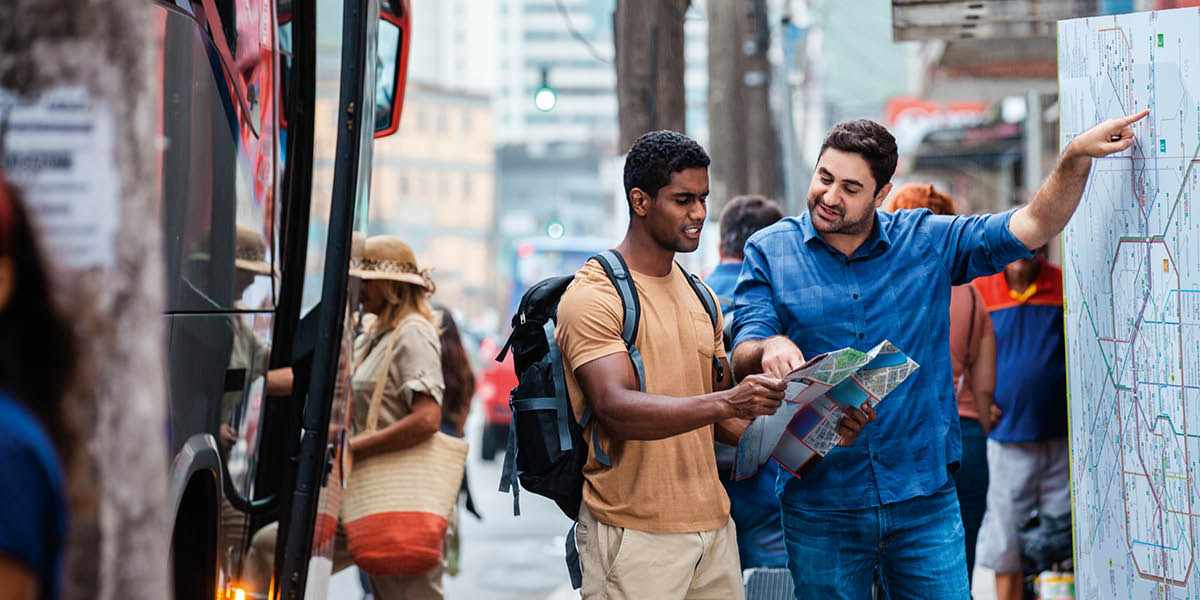 Un homme indique le chemin à un autre homme en se servant d’un plan.