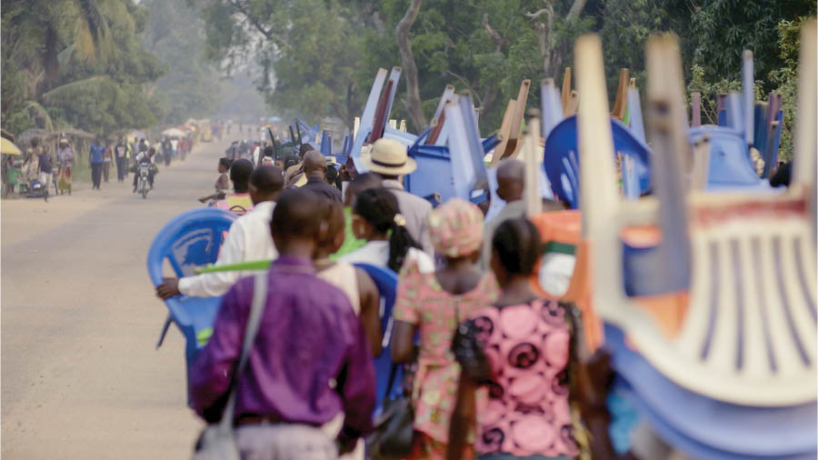 Image extraite de la vidéo « L’amour ne disparaît jamais malgré... La pauvreté (Congo) ». Un grand nombre de frères et sœurs se rendent à pied sur un lieu d’assemblée. Beaucoup transportent des chaises et autres effets personnels.