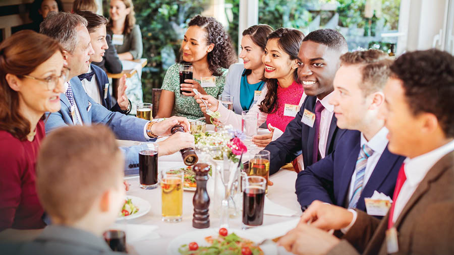 Des frères et sœurs de différentes races prennent un repas ensemble après avoir assisté à une assemblée régionale.