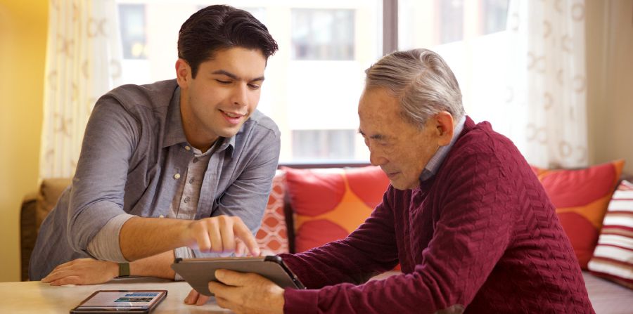 Un jeune frère aide un frère âgé à utiliser sa tablette