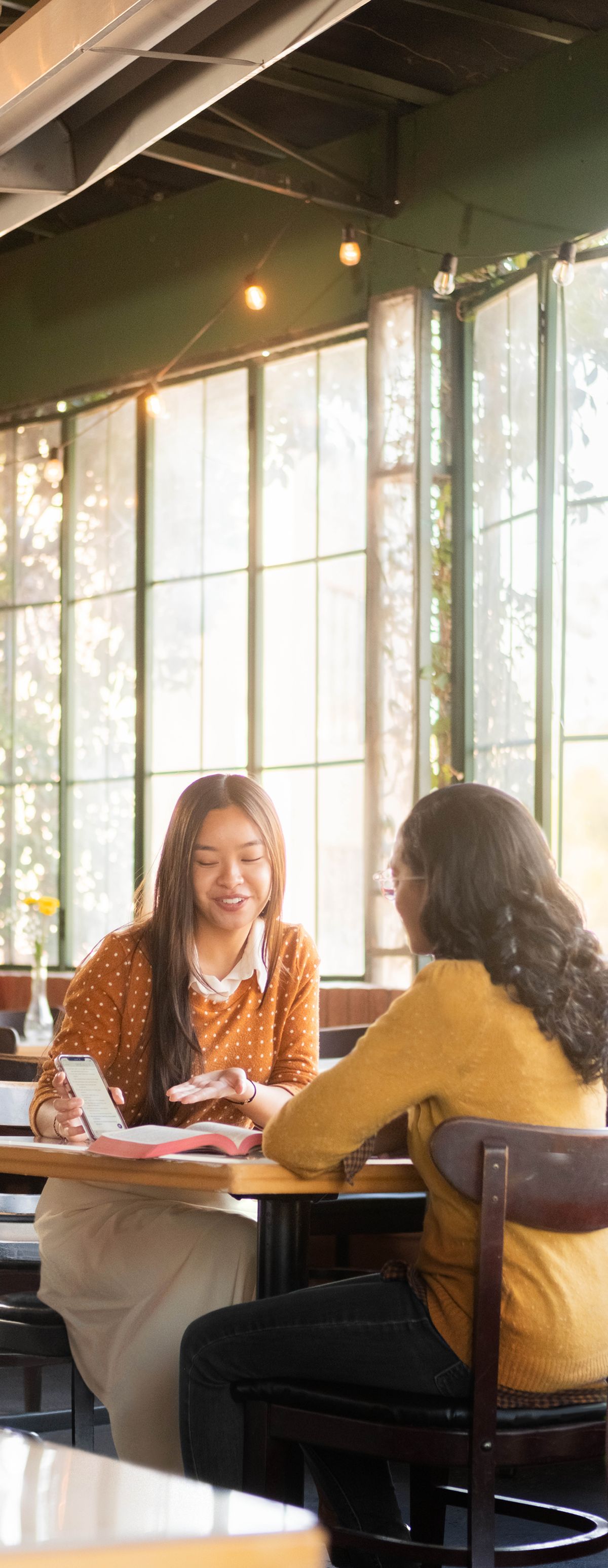 Peteĩ testígo de Jehová ostudia la Biblia peteĩ kuñataĩndi kafeteríape.