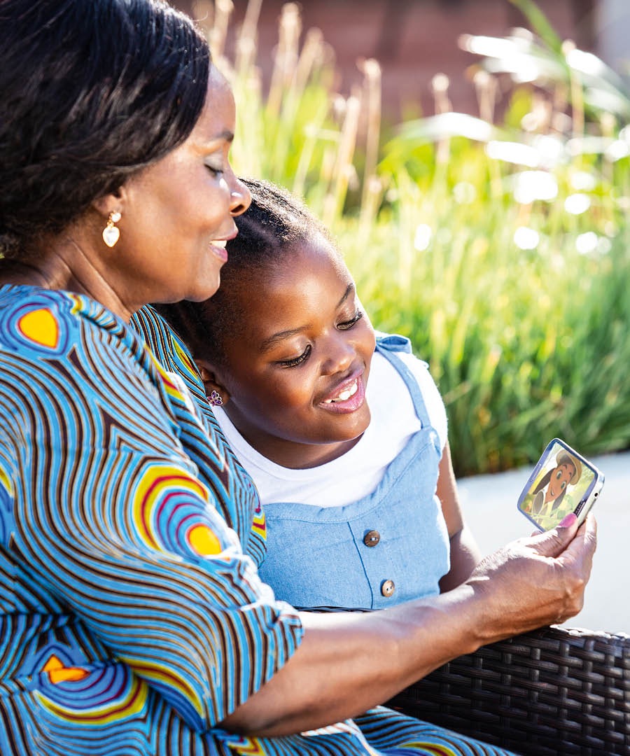 A woman shows a little girl a Bible-based video