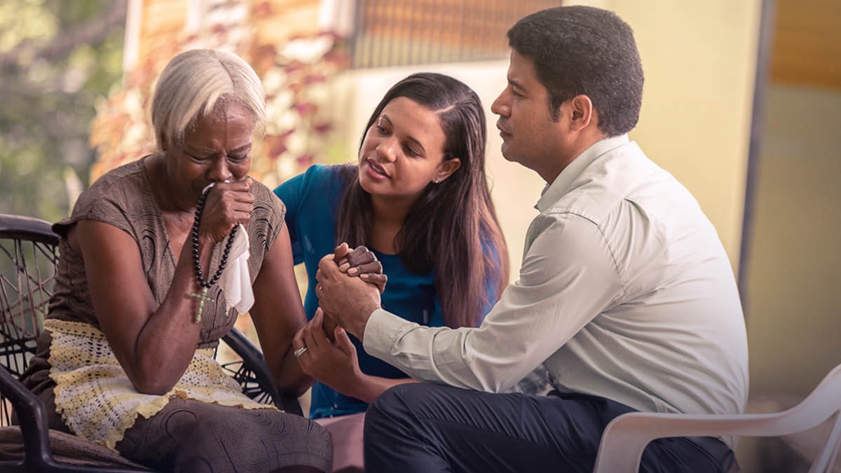 A Witness couple comfort a grieving relative who has lost a loved one