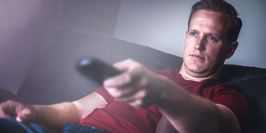 Man watching television changes the channel