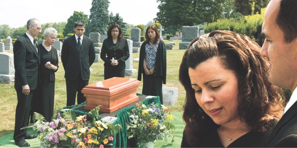 Syrgjendur við litla líkkistu í kirkjugarði