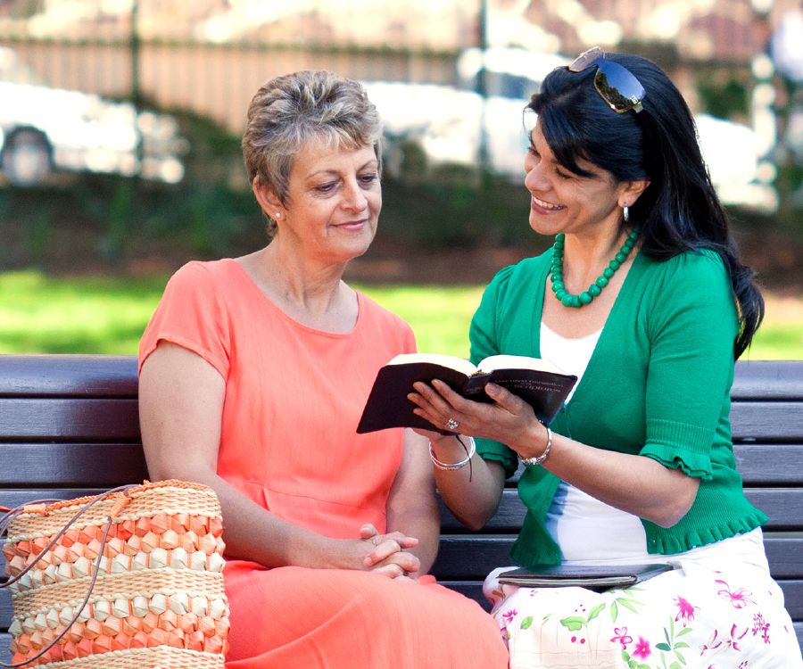 One of Jehovah’s Witnesses reads a scripture to a woman
