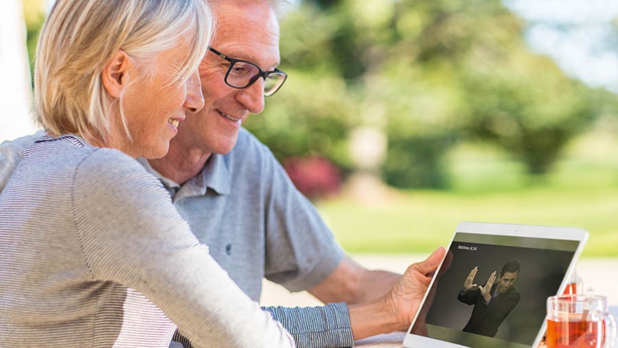 Una mamma ascolta una registrazione audio della Bibbia mentre piega i vestitini della figlia