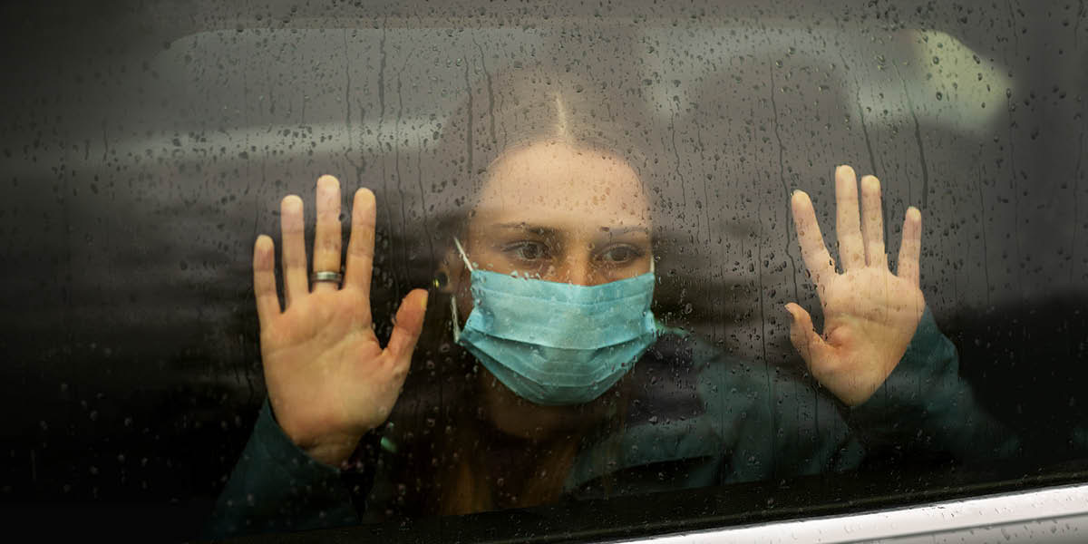 Ragazza guarda attraverso un vetro.