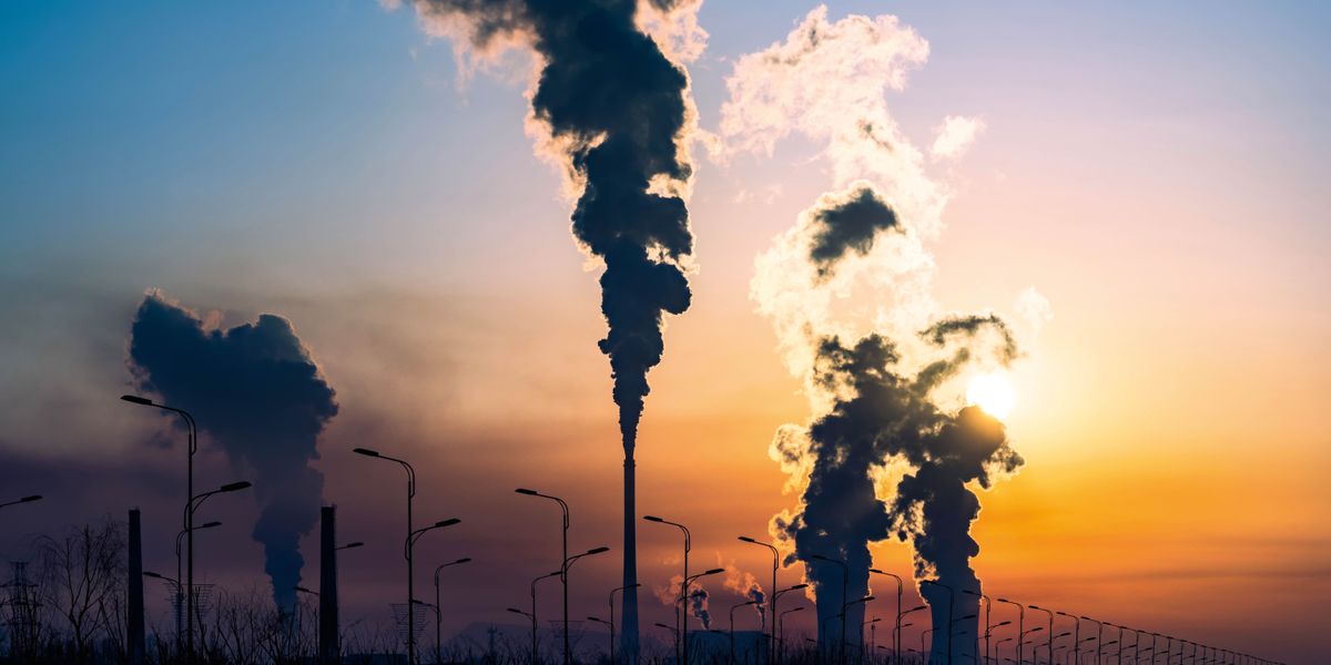 Fumo esce da alcune ciminiere e inquina l’ambiente.