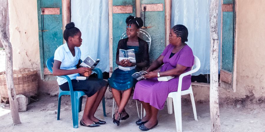 Gérole e sua figlia studiano la Bibbia con una ragazza ad Haiti