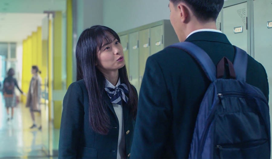 学校の廊下でミキョンがジンに話し掛けている。