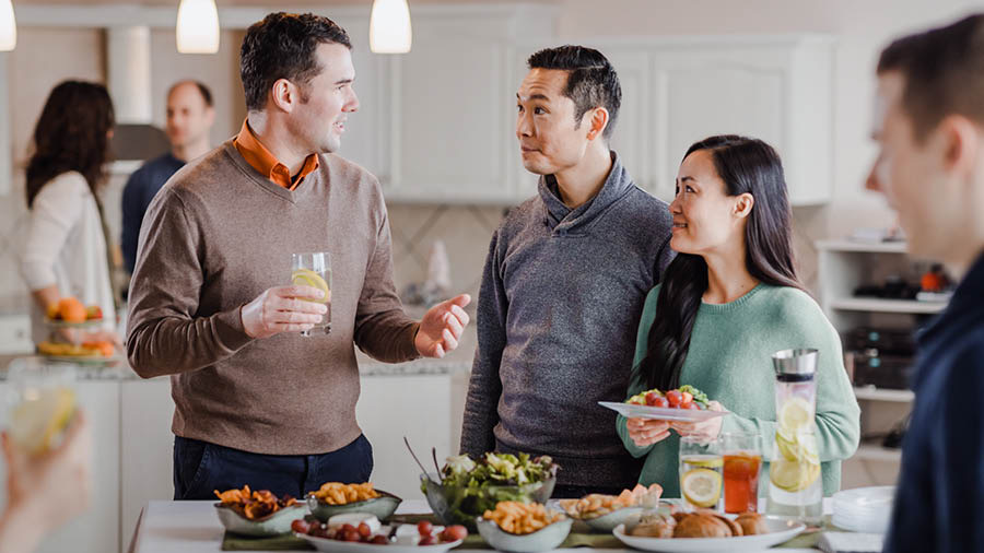 その兄弟が，会衆の兄弟姉妹と一緒に軽食を取りながら，楽しく話している。