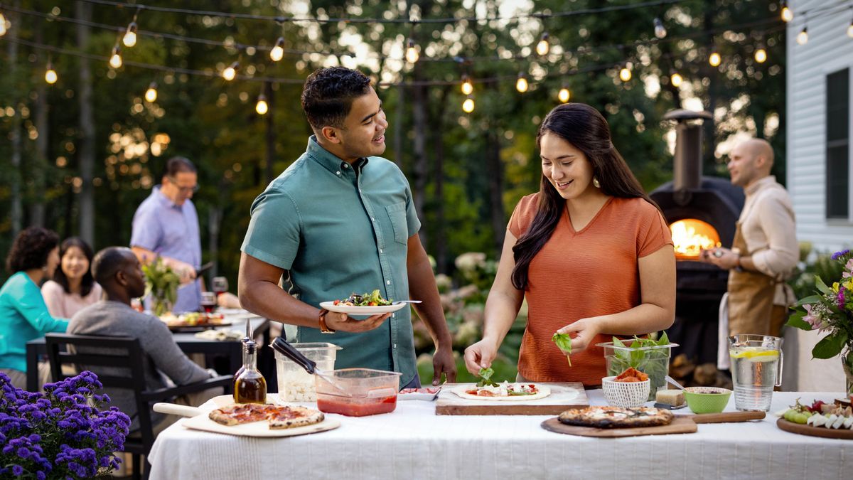 先ほどの独身の兄弟と姉妹が，会衆の人たちとの食事会で会話している。