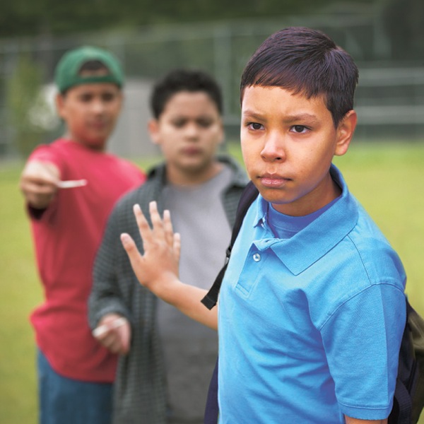 A boy resisting the temptation of cigarettes from his peers