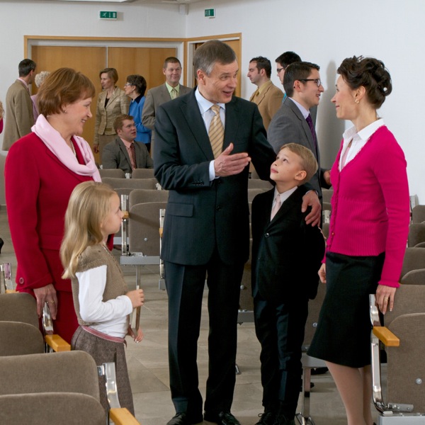 An elder talking with members of the congregation