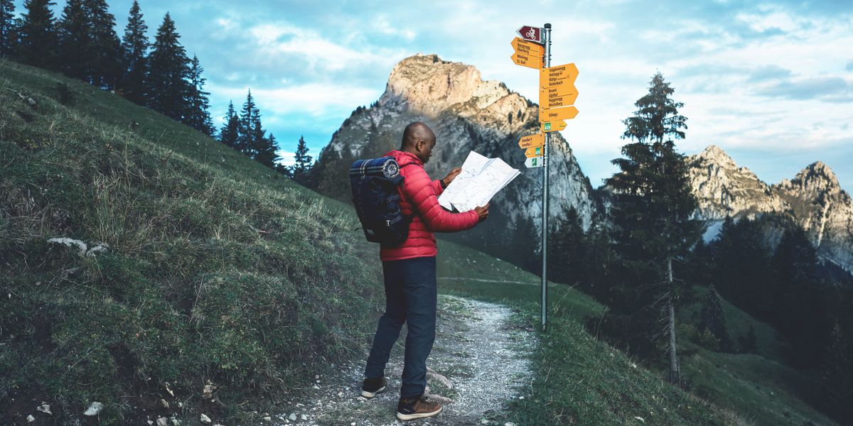 Kel ómi ki staba na kes otu artigu ki pasa sta paradu na kaminhu di un montanha timenti el sta ta djobe pa un mapa. Na se frenti sta un pósti ku txeu plaka ki sta mostra direson, i di lonji nu ta konsigi odja un montanha.