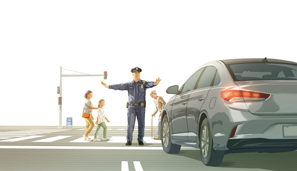 A police officer stopping traffic at a busy intersection. People of various ages walk across the street.