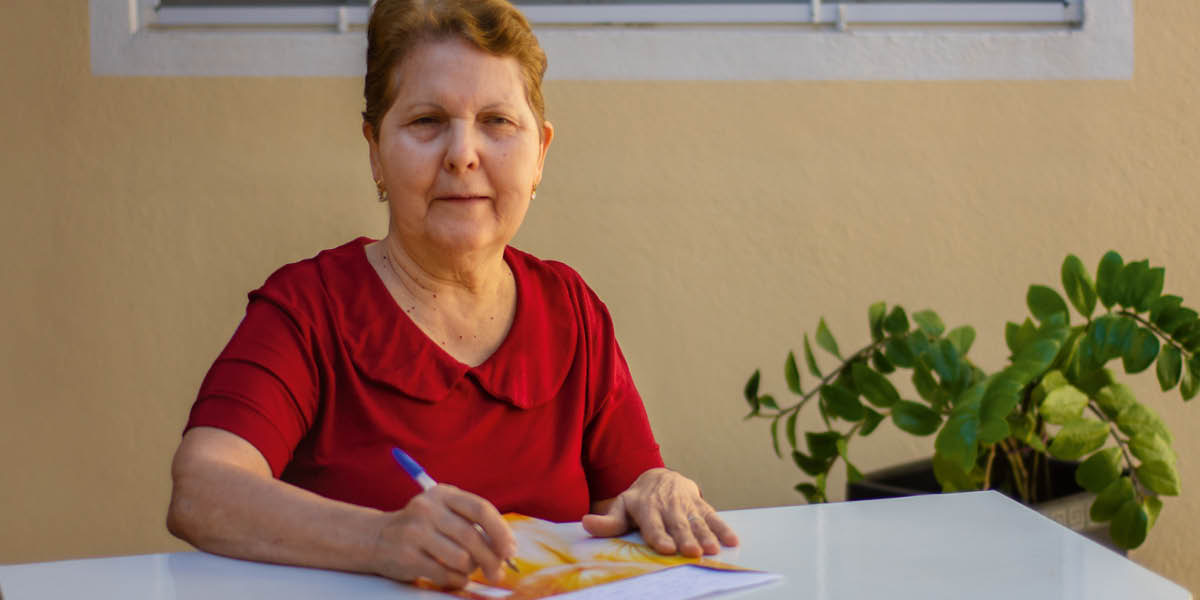 Maria Lúcia ufunda mukanda.