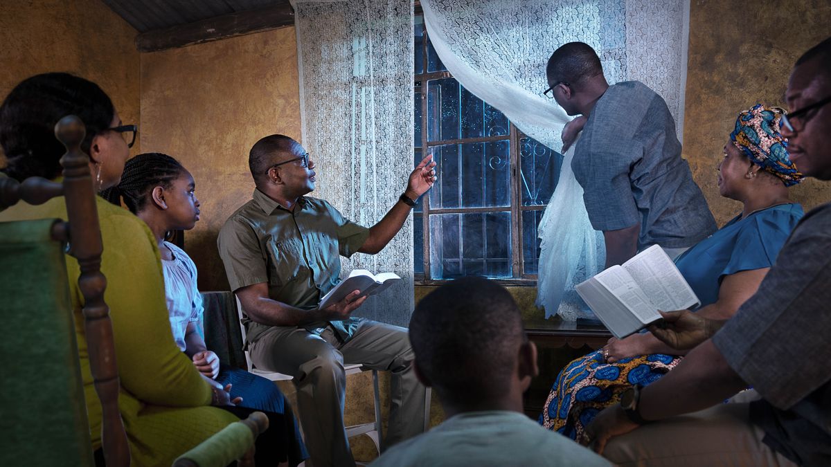 Bena Kristo babala Bible pamue mu nzubu mu dikenga dinene. Mbatangidile pambelu mu dididishi, muanetu wa balume uleja mitoto ya bungi muulu butuku.