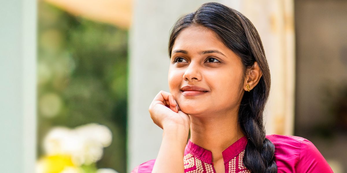 ഒരു ചെറുപ്പക്കാരി സന്തോഷത്തോടെ ജനലിലൂടെ പുറത്തേക്കു നോക്കിയിരിക്കുന്നു.