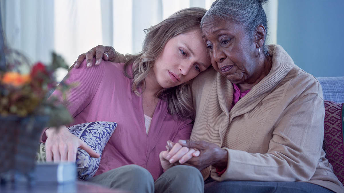 एक जना पाको दिदी एउटी जवान बहिनीलाई अङ्‌गालो हालेर सान्त्वना दिँदै छिन्‌।