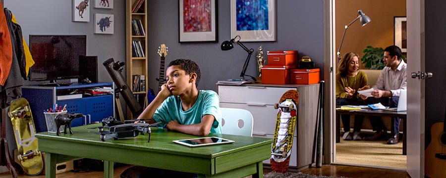 Een jongen is ongelukkig terwijl hij in een kamer vol spullen zit