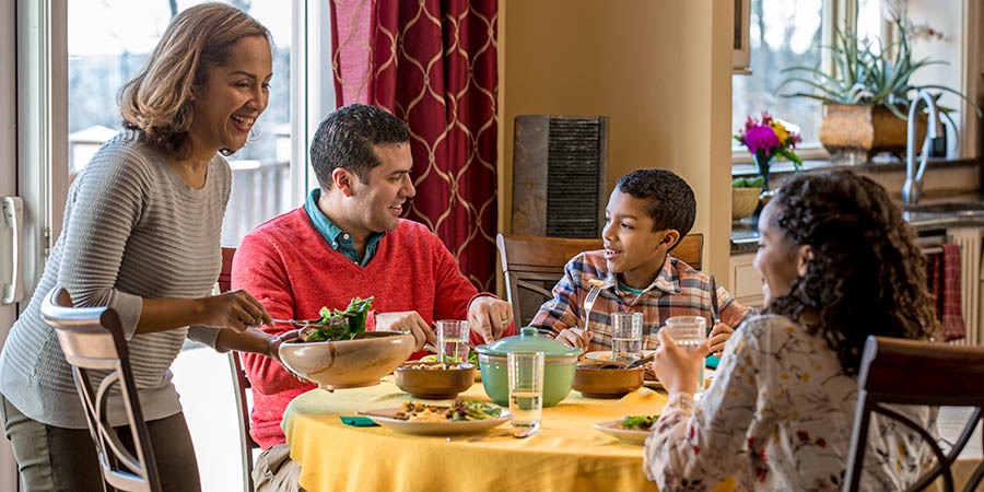 Een gezin zit tijdens het eten gezellig te praten