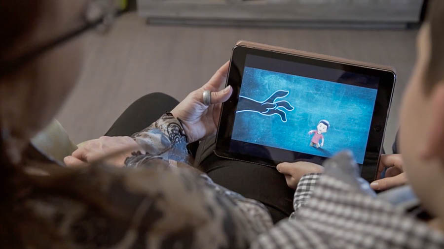 Een scène uit de video ‘Bouw een huis dat zal standhouden — Bescherm je kinderen tegen “het kwade”’. Een moeder en haar zoontje kijken naar de video ‘Bescherm je kinderen’.