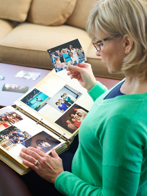 Een zuster bladert door een fotoalbum en denkt terug aan de tijd dat ze Jehovah actief diende