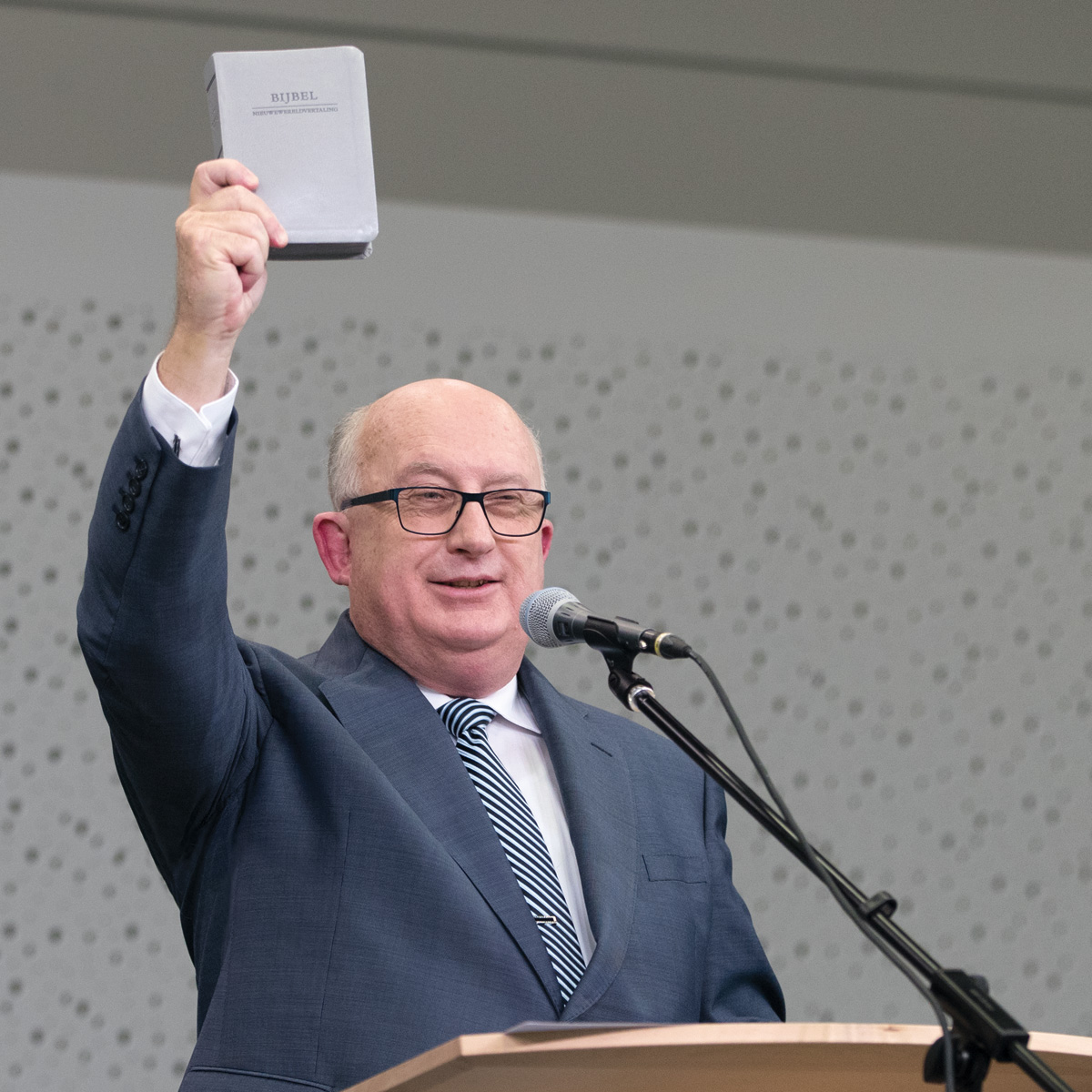 Een broeder van het Besturende Lichaam die de herziene vertaling omhooghoudt