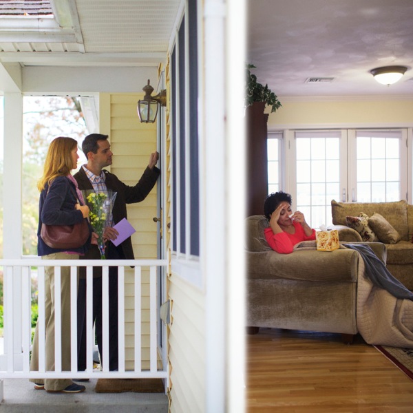 A husband and wife bringing flowers and a card to a sick friend who is in her home alone