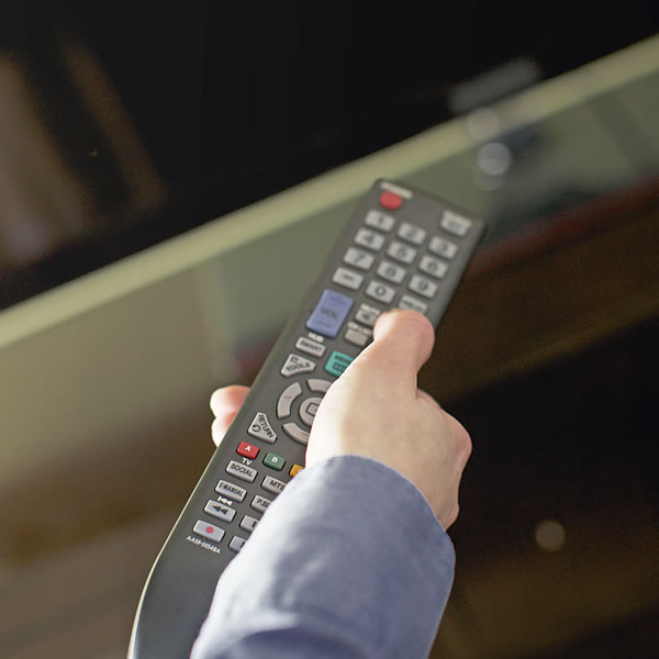 Ktoś używający pilota do telewizora