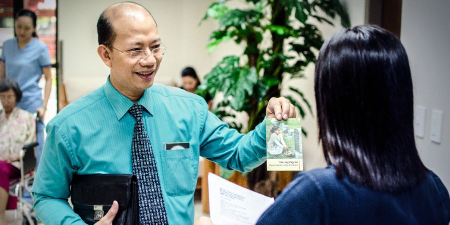 Jonathan wręcza traktat recepcjonistce w przychodni na Filipinach