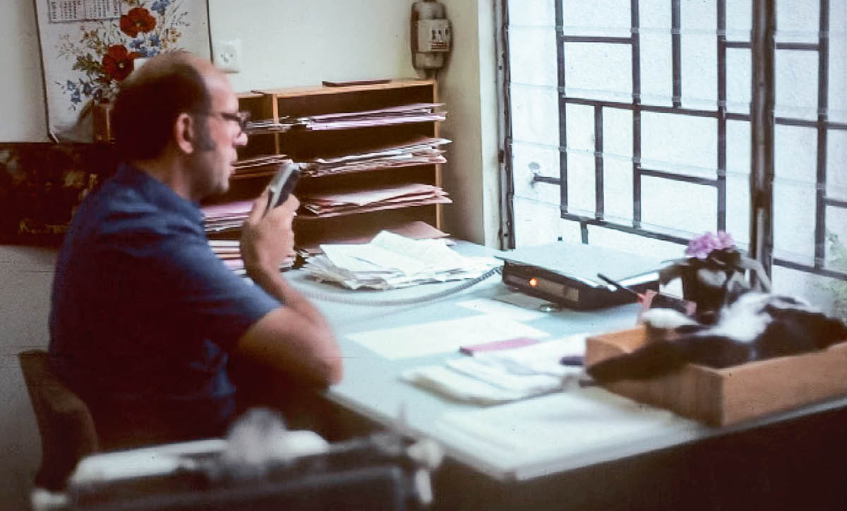 Dayrell em seu escritório usando um ditafone.