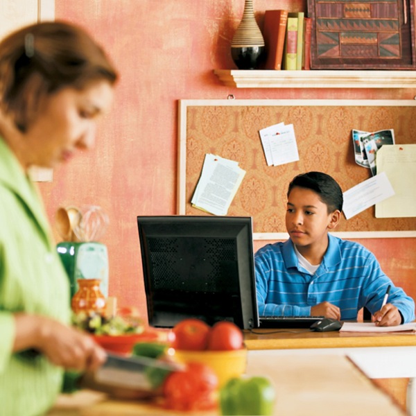 Um jovem usando computador numa área de livre acesso de sua casa