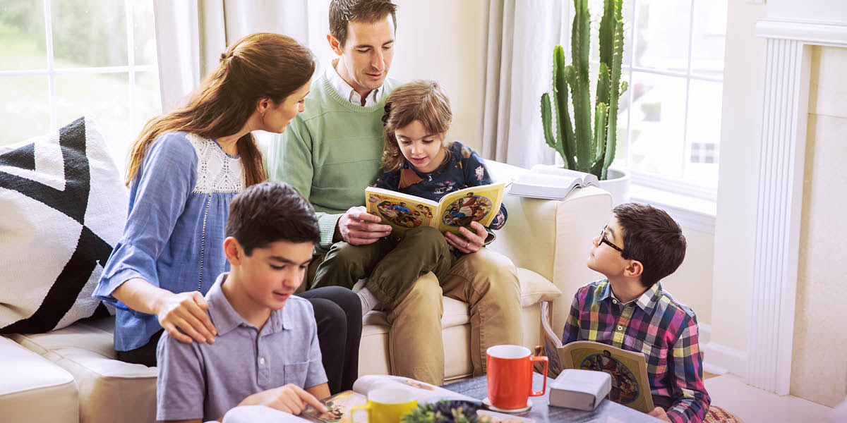 Pais estudando com seus filhos usando o livro “Aprenda do Grande Instrutor”.
