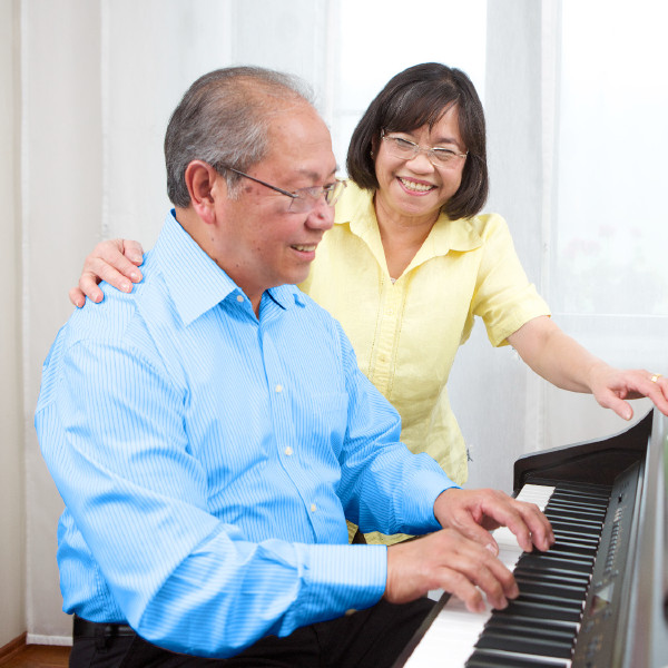 Um idoso toca piano para sua esposa