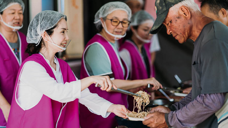 A mesma mulher servindo comida para os pobres e desabrigados.