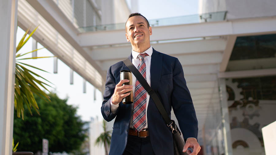 O homem que tinha perdido o emprego caminhando lá fora e sorrindo.