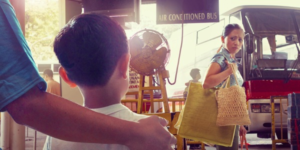 Ao partir, Mariane olha com tristeza para seu marido, Tiago, e para Júnior, seu filho