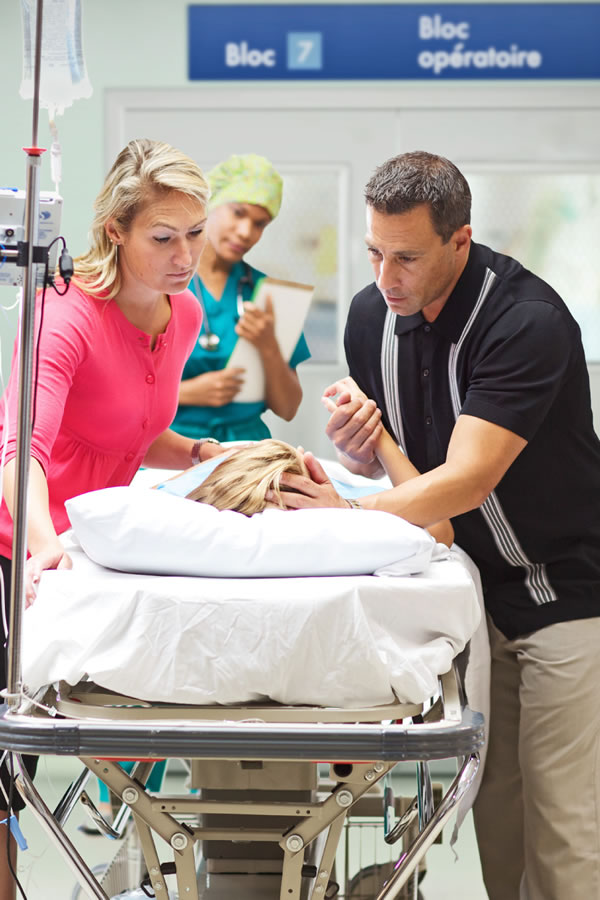 Părinţi stând la căpătâiul copilului lor bolnav