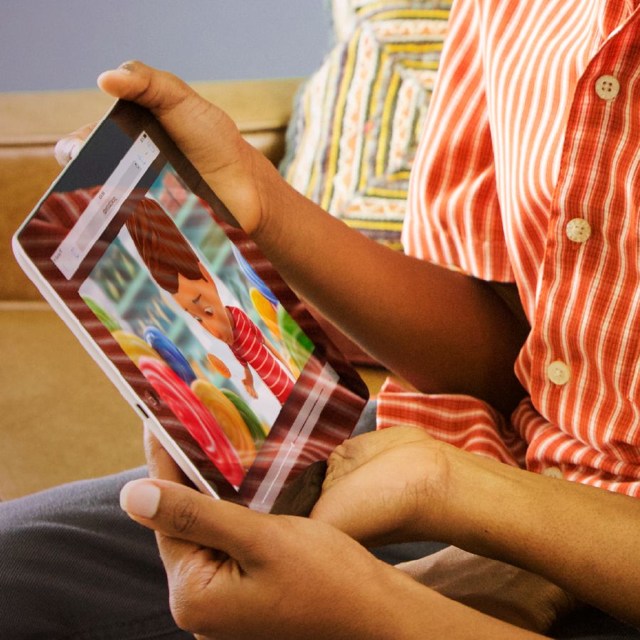 Un băiat urmărește materialul video „Este greșit să furi” pe jw.org