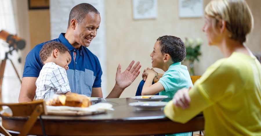 Un bărbat vorbește cu soția și cu copiii săi