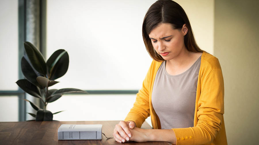 A sister praying before reading the Bible.