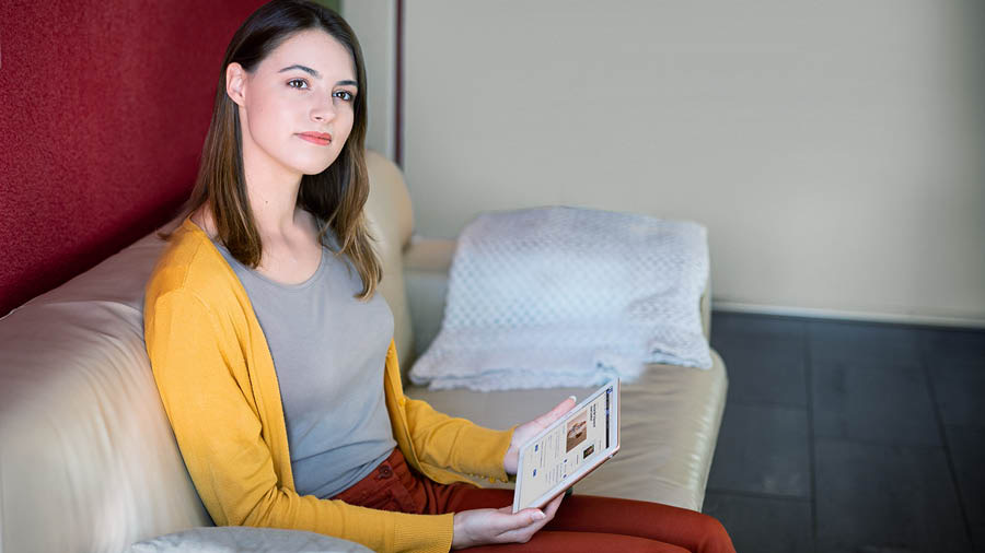 La sœur médite sur ce qu’elle a lu dans la Bible et consulte le livre « Rends pleinement témoignage au sujet du Royaume de Dieu ».