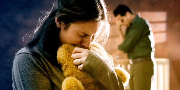 Një burrë e një grua vajtojnë për humbjen e fëmijës