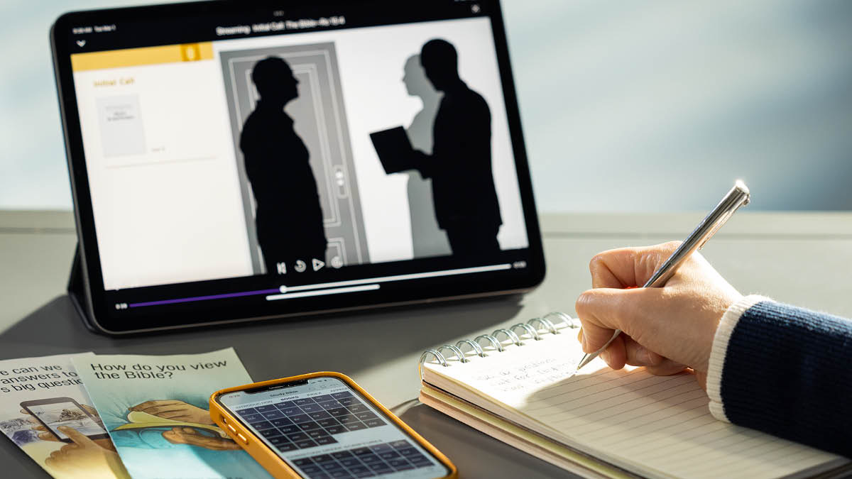 Morali oabo rona o ngola lintlha ha a ntse a shebeletse video ea mehlala ea seo re ka se buang le batho. Pel’a hae ho na le lipampitšana le fono e hlahisitseng JW Library.